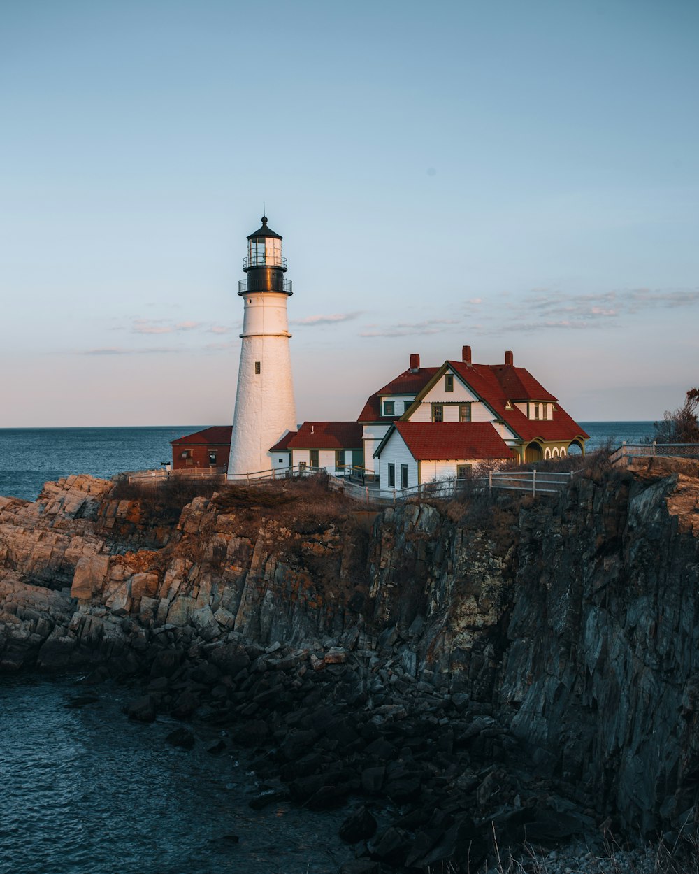 a lighthouse on a rocky cliff near the ocean