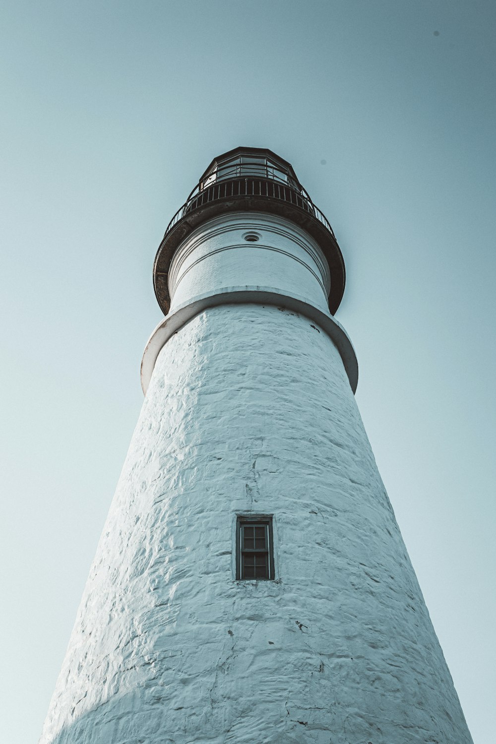 a tall white lighthouse with a sky background