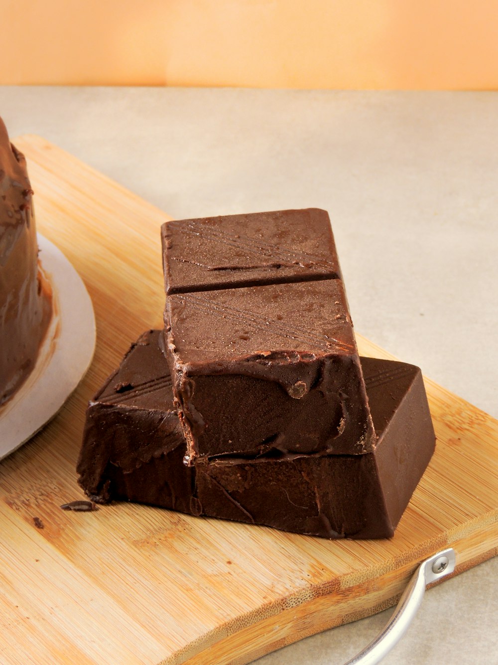 a piece of chocolate cake sitting on top of a wooden cutting board