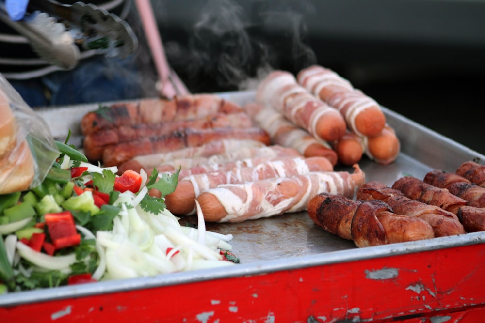 a bunch of hot dogs on a grill