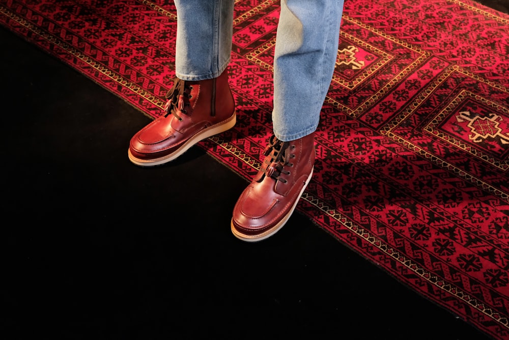 a person standing on a rug wearing red shoes