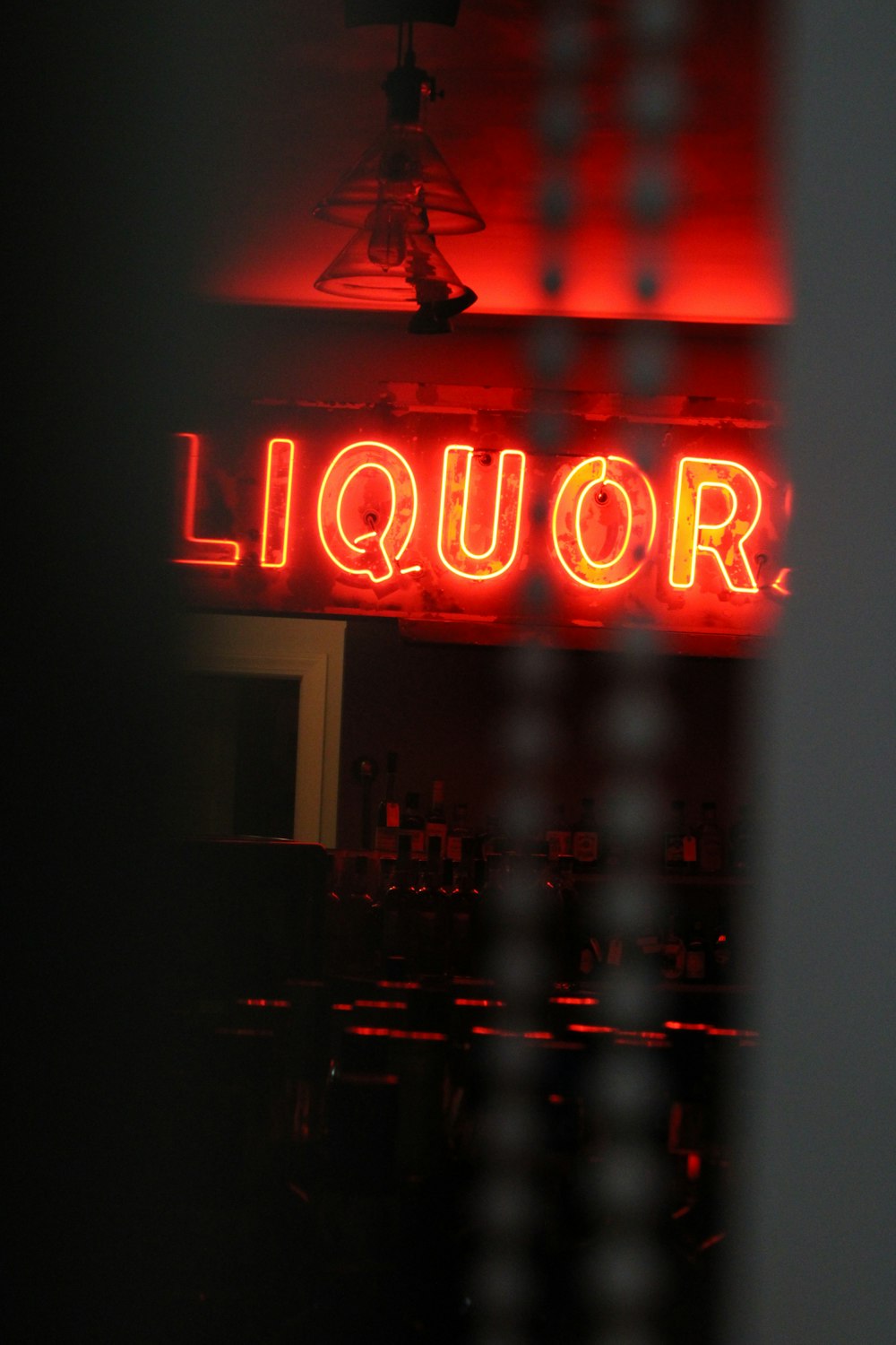 a liquor sign lit up in the dark