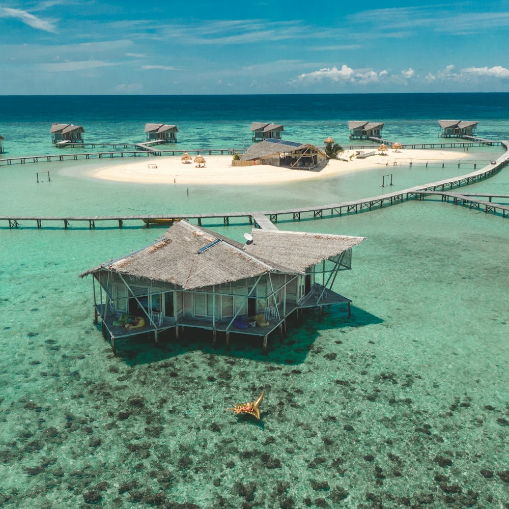 a house on a beach with a pier in the background