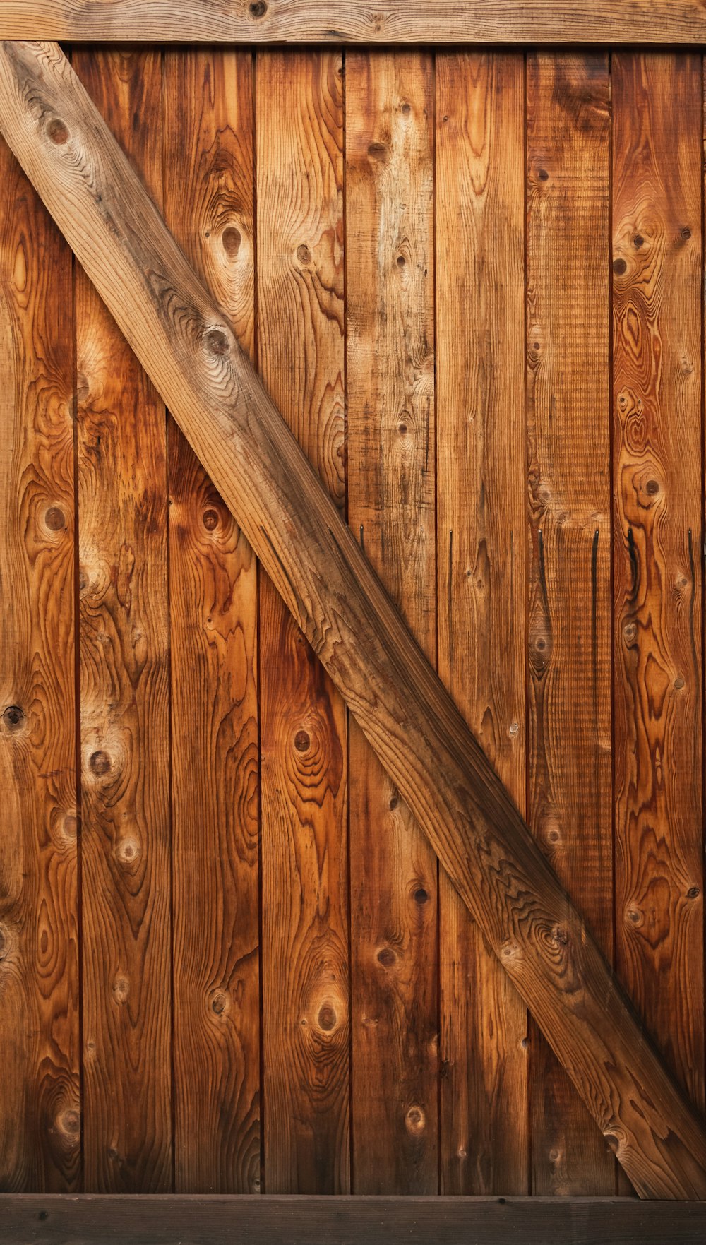 a close up of a wooden fence with a wooden pole