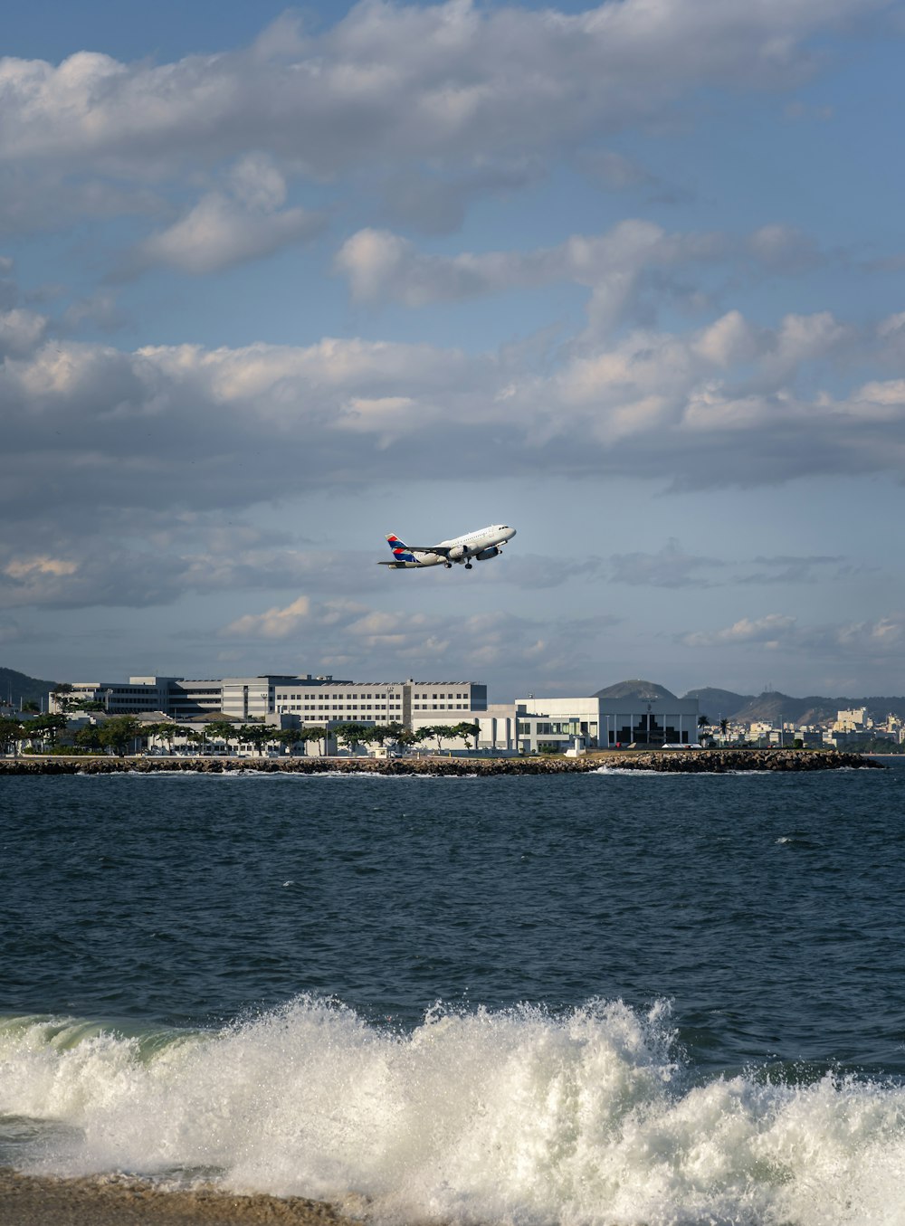 Ein großer Jetliner fliegt über ein Gewässer