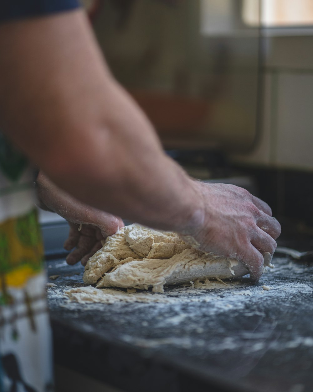 a person kneading dough on top of a counter