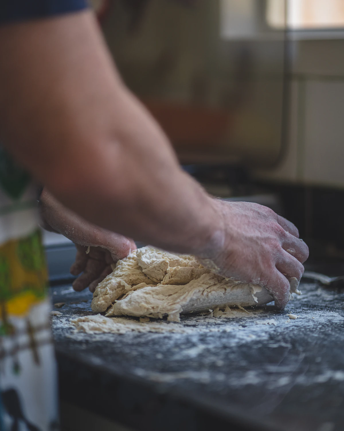 Mani al lavoro sull'impasto della pizza