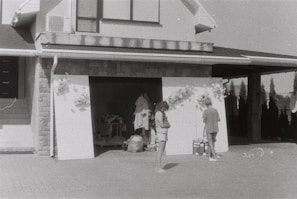A family photo of the shop owners standing proudly in front of their garage.