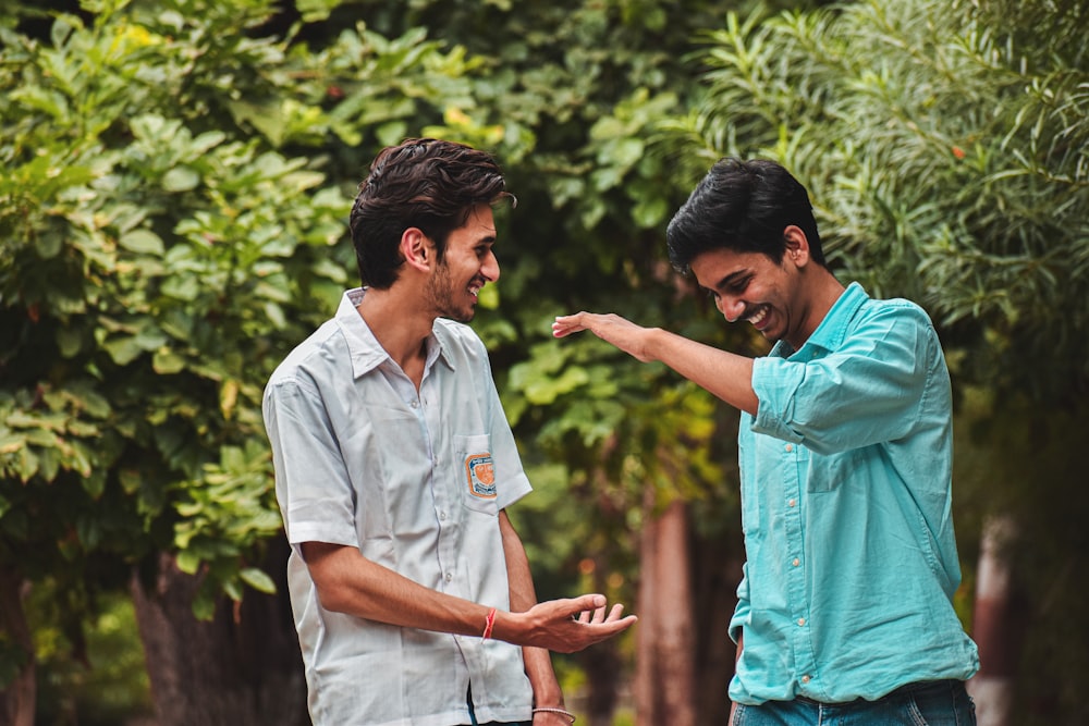 two men standing next to each other pointing at something