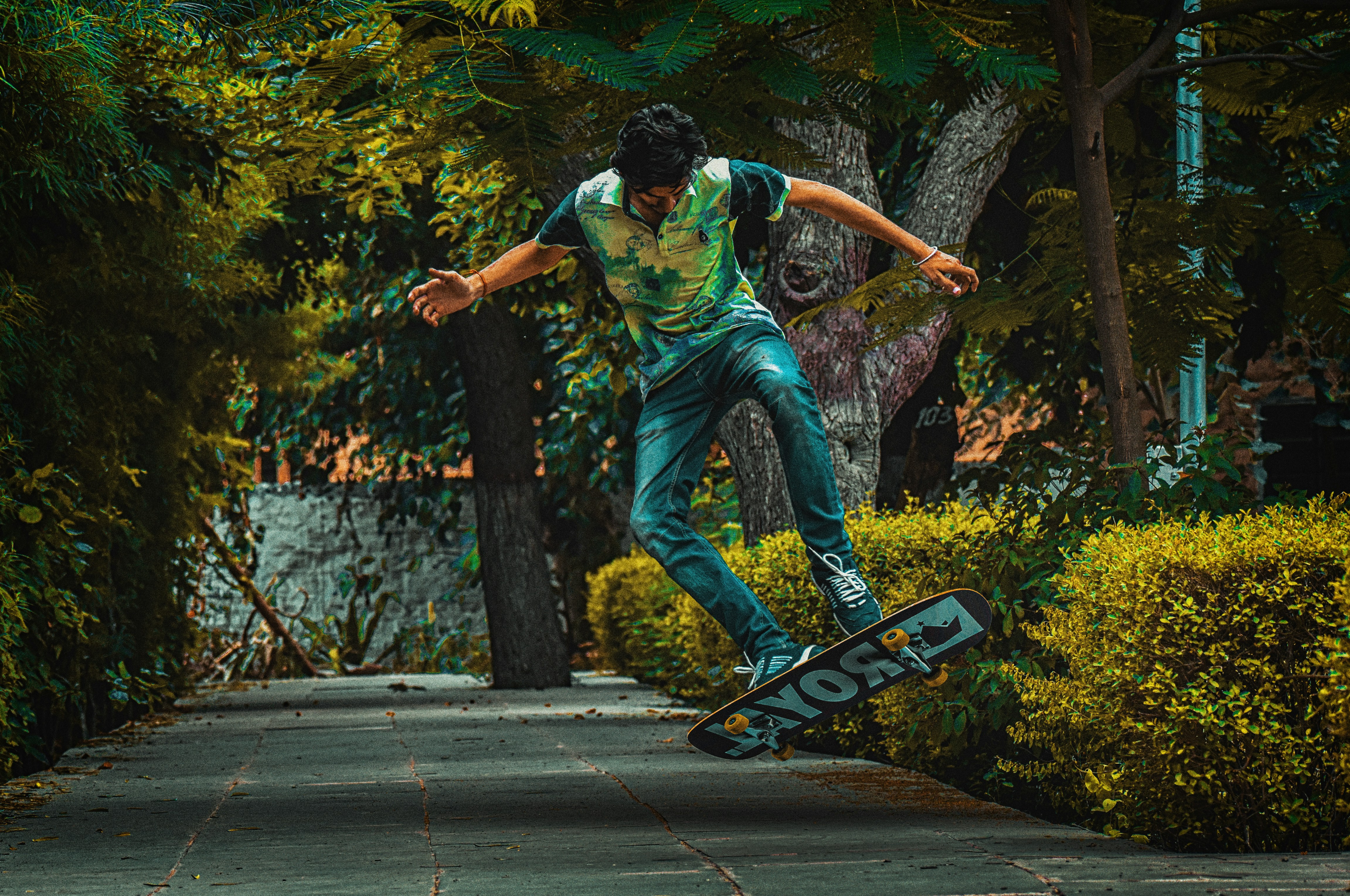 Seorang pria mengendarai skateboard di trotoar