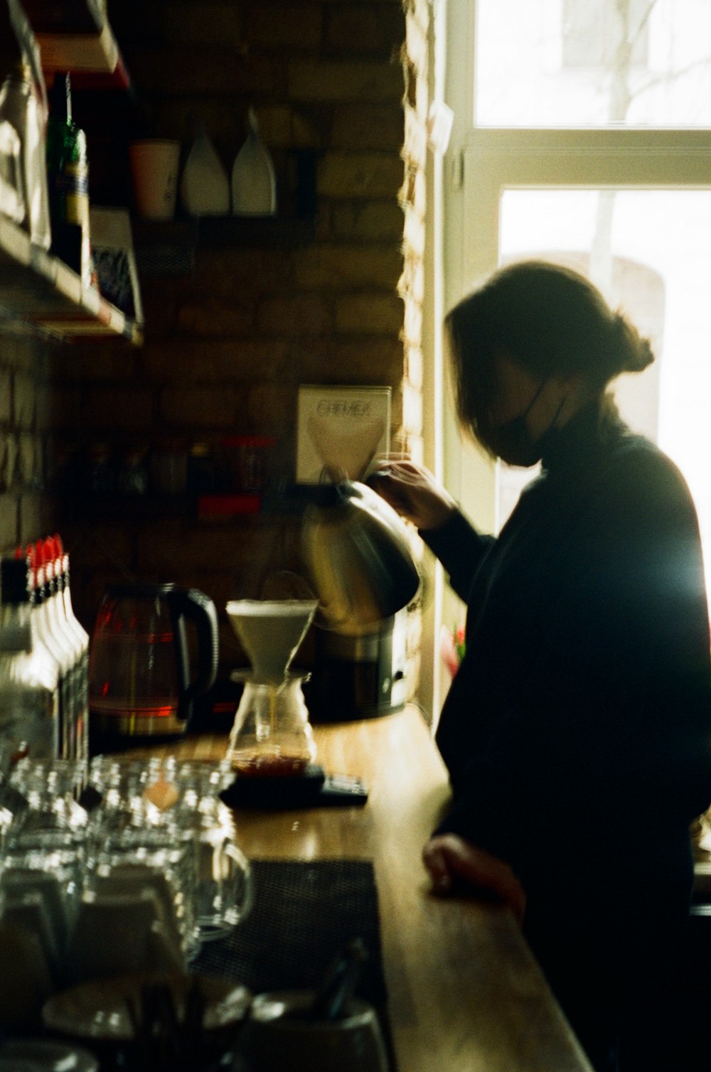 a woman pours a cup of coffee in a kitchen