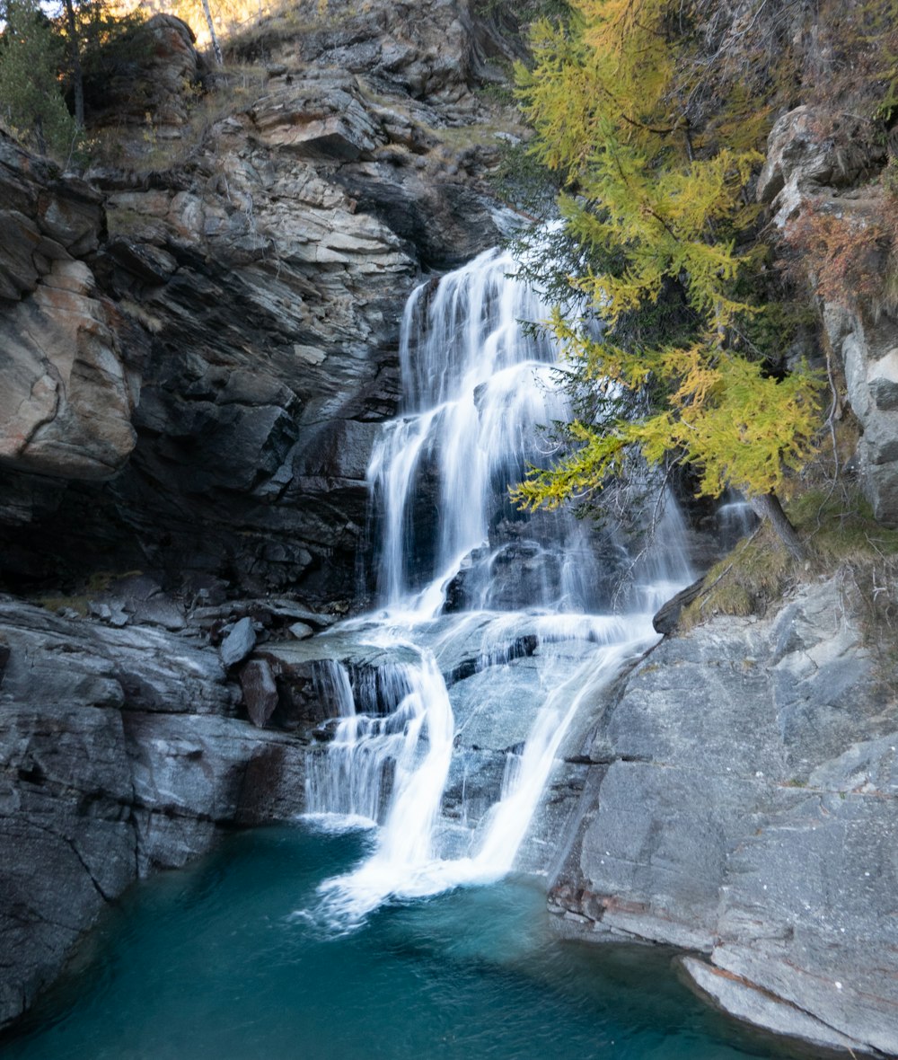 a waterfall with a blue pool in the middle of it