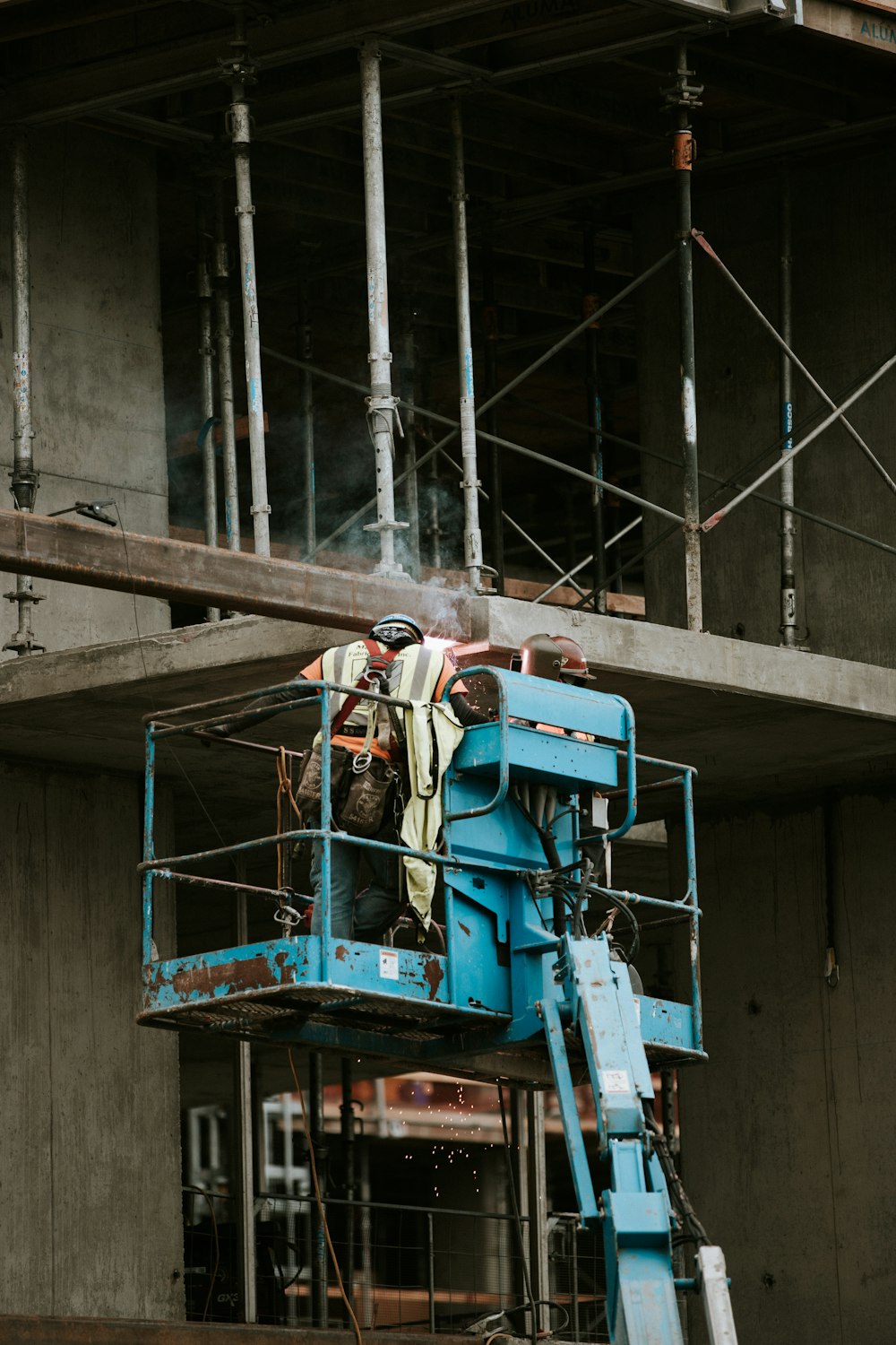 a man standing on a scaffolding machine in front of a building