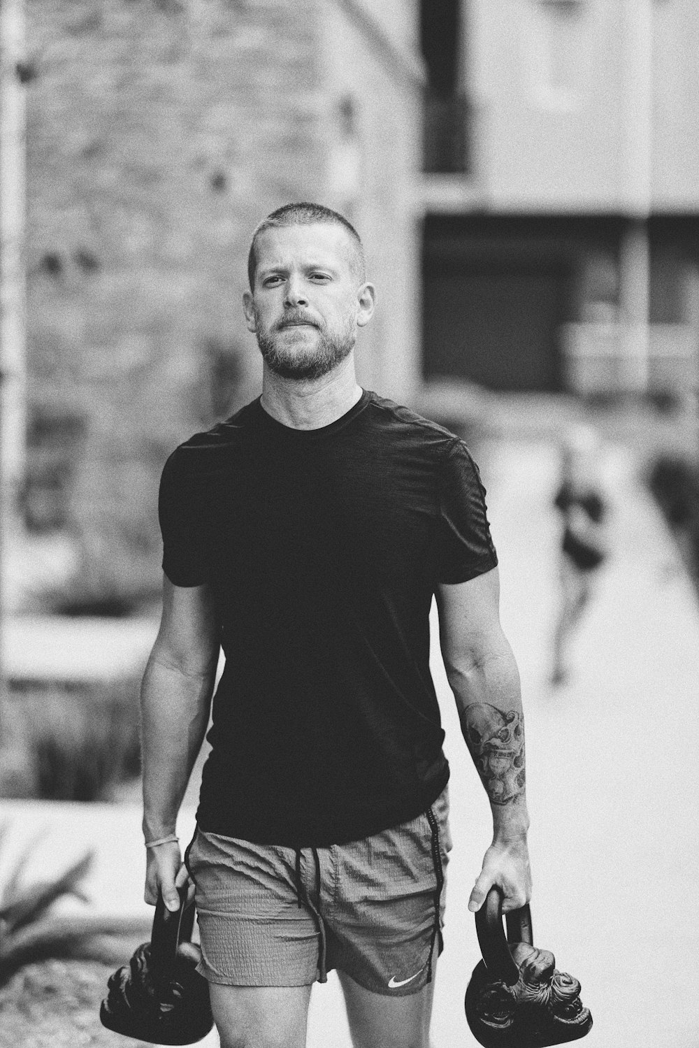 a man walking down a street holding a skateboard