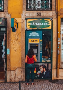 a woman standing in front of a atm machine