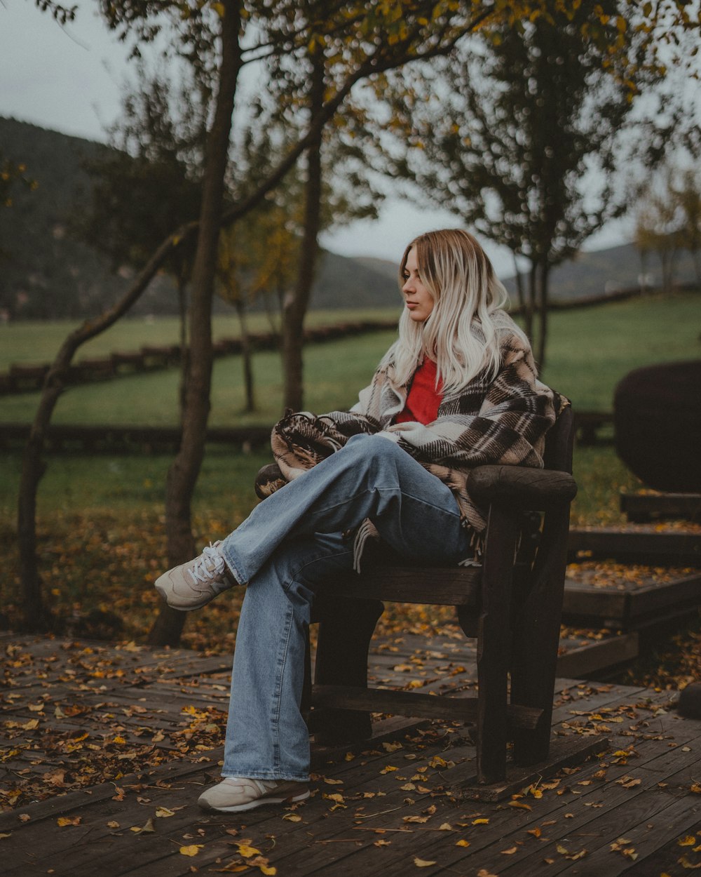 a woman sitting on a bench in a park