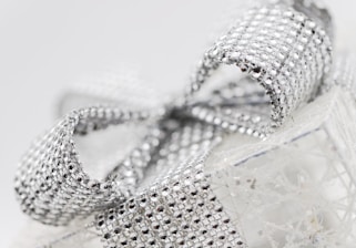 a close up of a silver ribbon on a white box