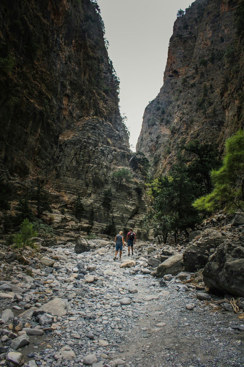 a couple of people standing on a rocky river