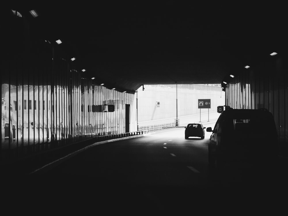 a black and white photo of a car in a tunnel