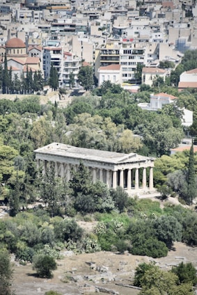 A group of city leaders from Greece and Cyprus collaborating outdoors with a backdrop of urban buildings and greenery.