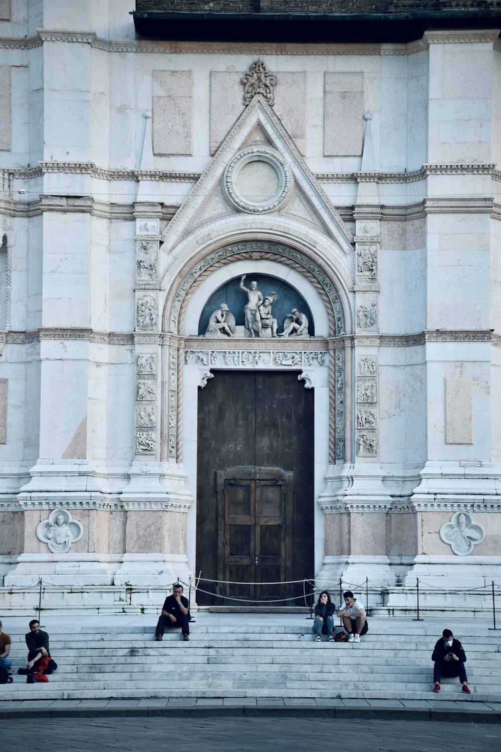 a group of people sitting on steps in front of a building