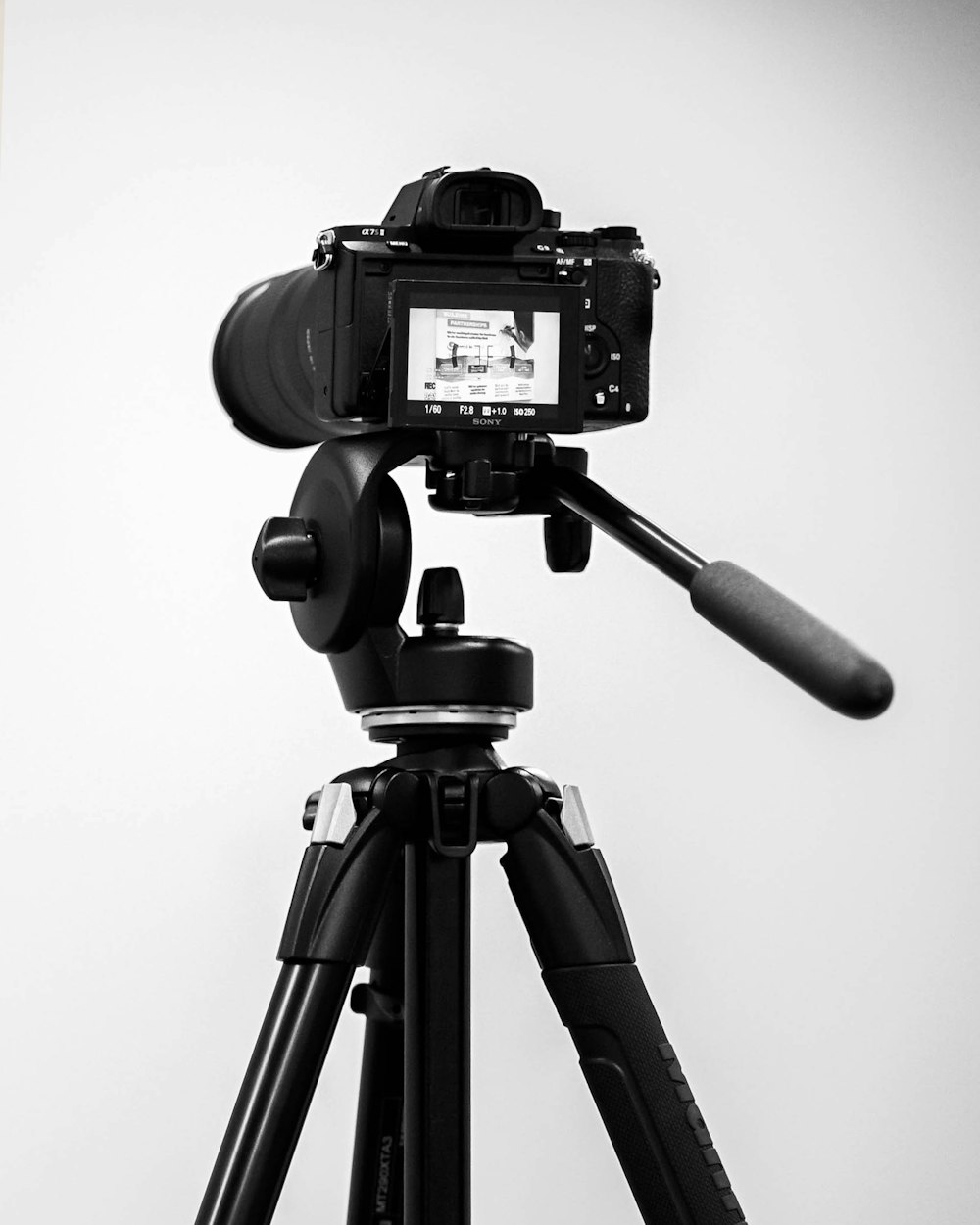 uma foto em preto e branco de uma câmera em um tripé