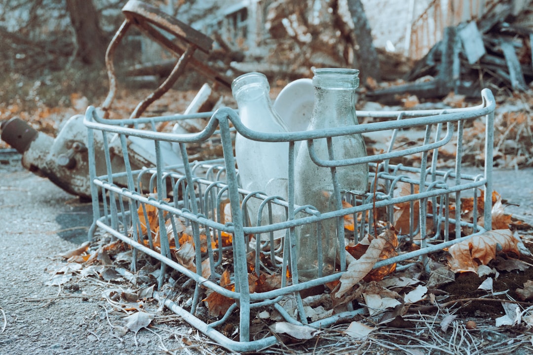 a broken dishwasher sitting on top of a pile of leaves,