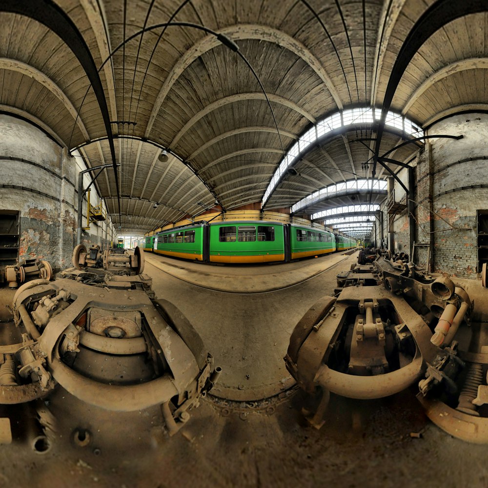 a green train traveling through a train station