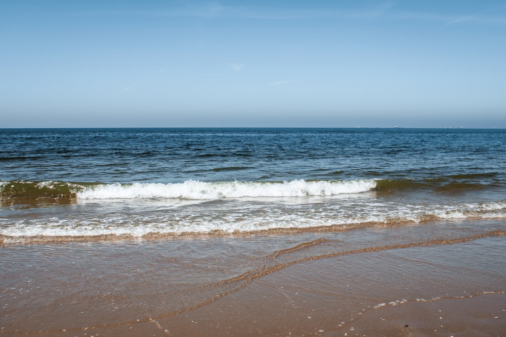 a beach with a wave coming in to shore