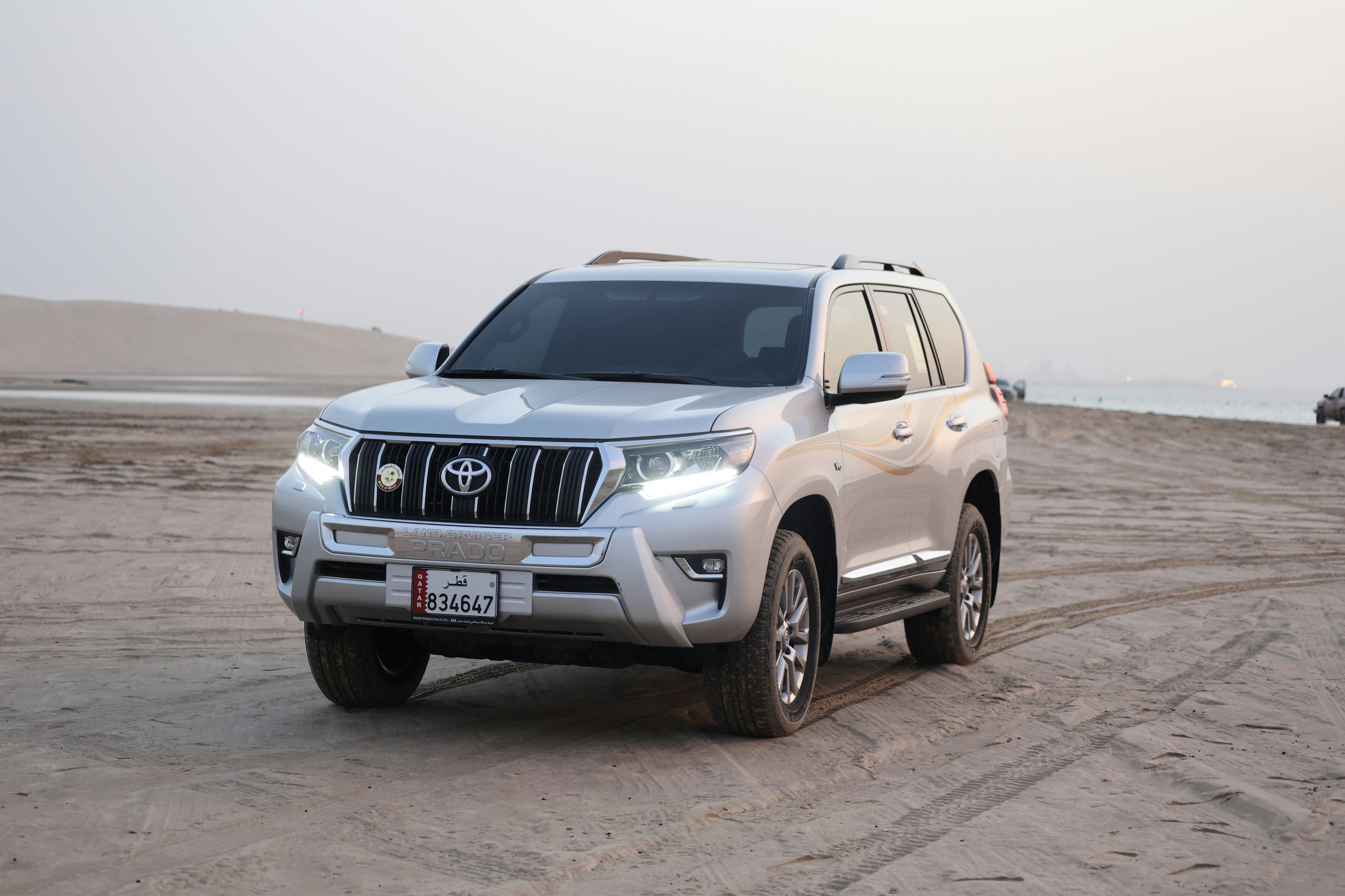 a silver suv parked on a sandy beachby Mohammad jahidul Islam