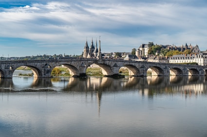 a bridge over a body of water with buildings in the background