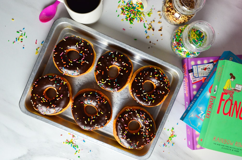 a tray of doughnuts with chocolate frosting and sprinkles