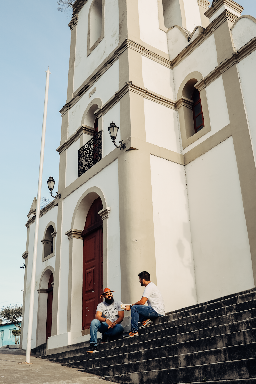 two men sitting on the steps of a church