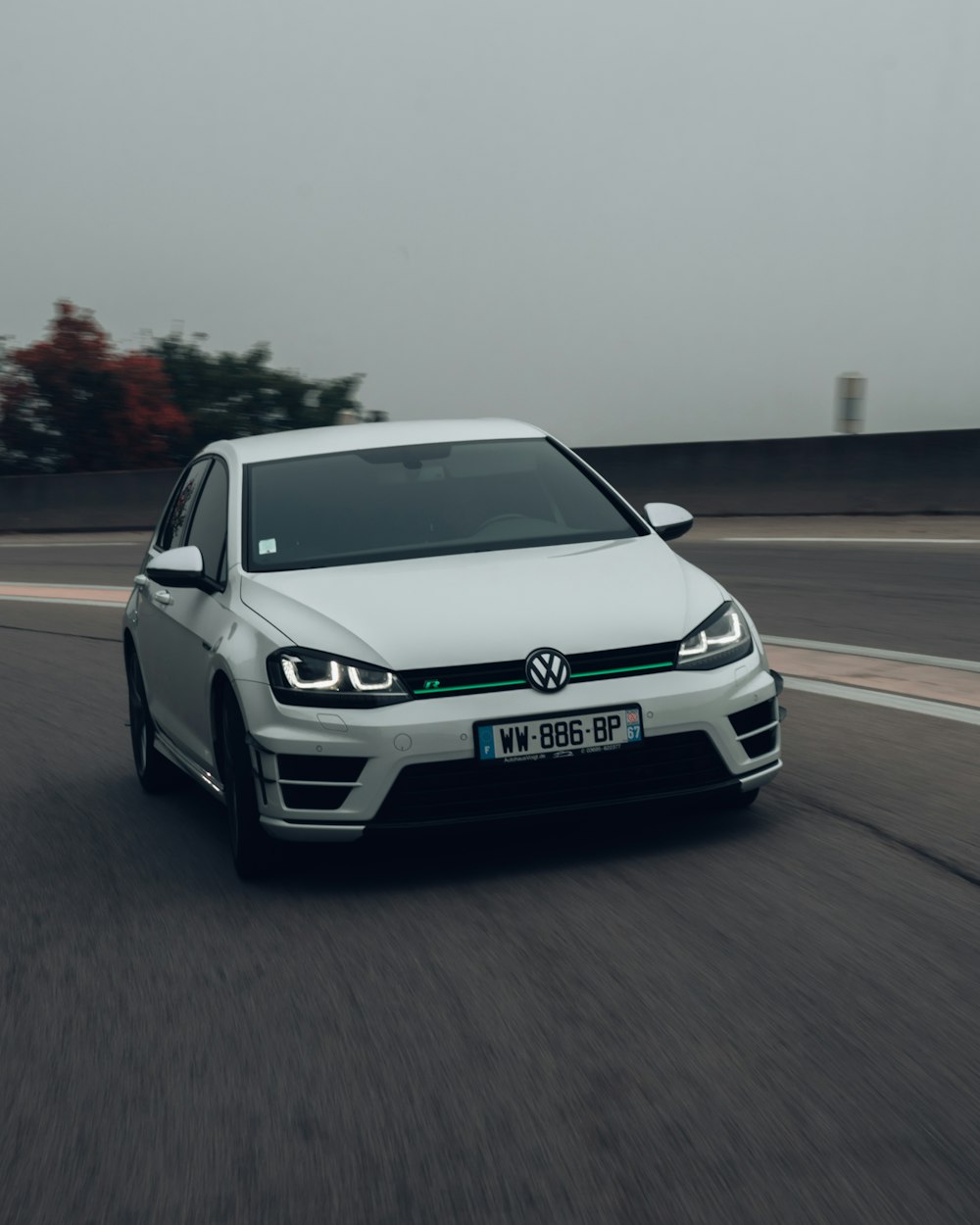 a white volkswagen car driving down a road