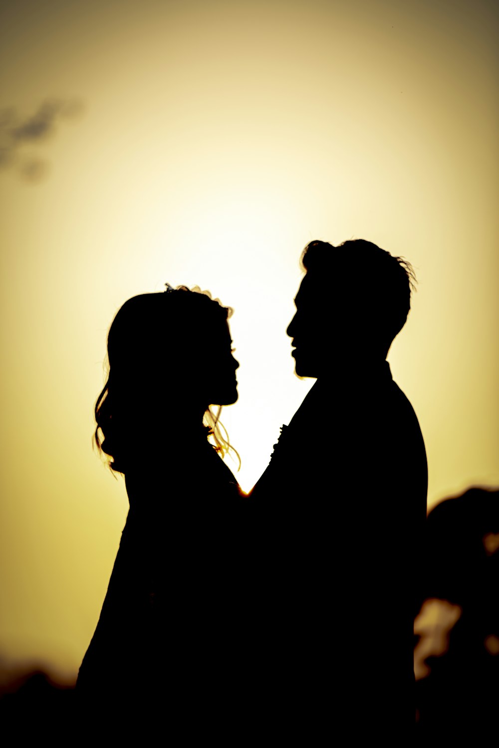 a silhouette of a man and a woman holding hands