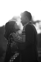 A warm, candid moment of a Tamil wedding couple sharing a joyful glance, vibrant sarees and rich cultural details around them.