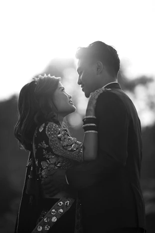 An intimate portrait of the couple exchanging garlands with warm smiles and sparkling eyes.