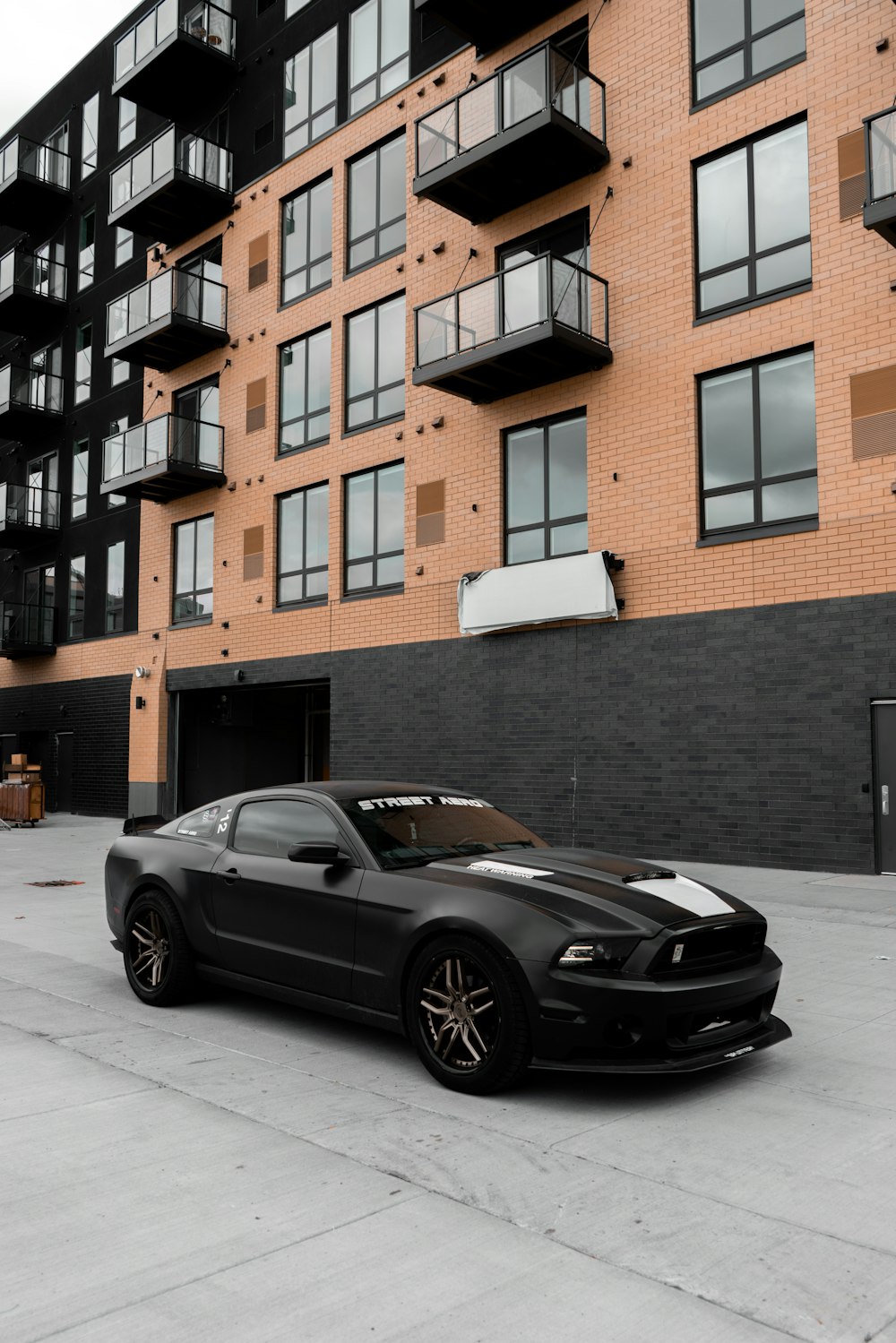 a black car parked in front of a tall building