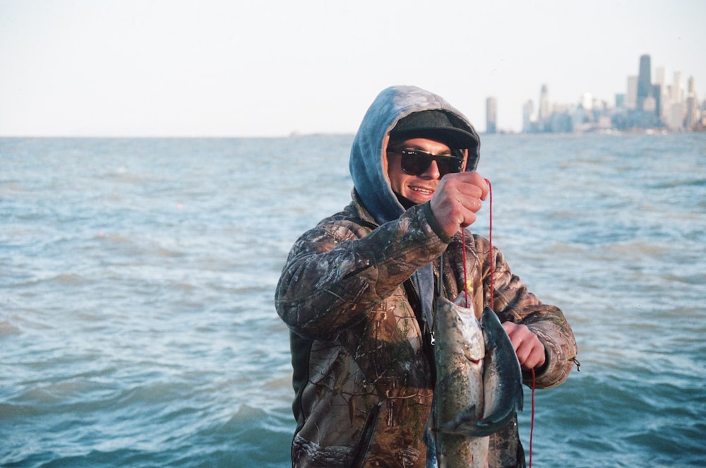 a man standing on a boat holding a fish