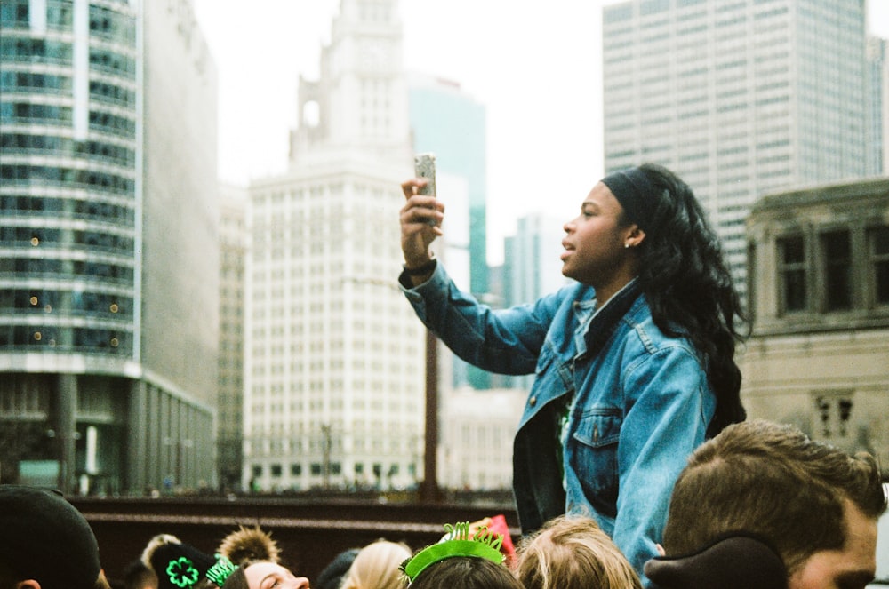 a woman taking a picture of a crowd of people