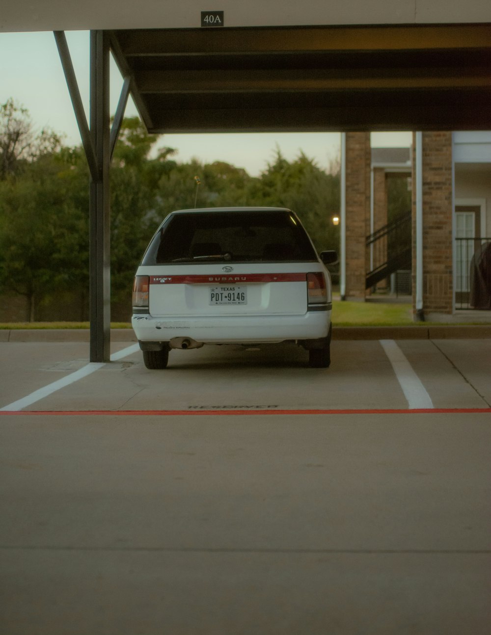 a white car is parked in a parking lot