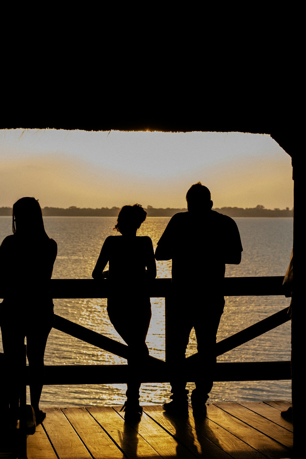 a group of people standing on top of a wooden pier