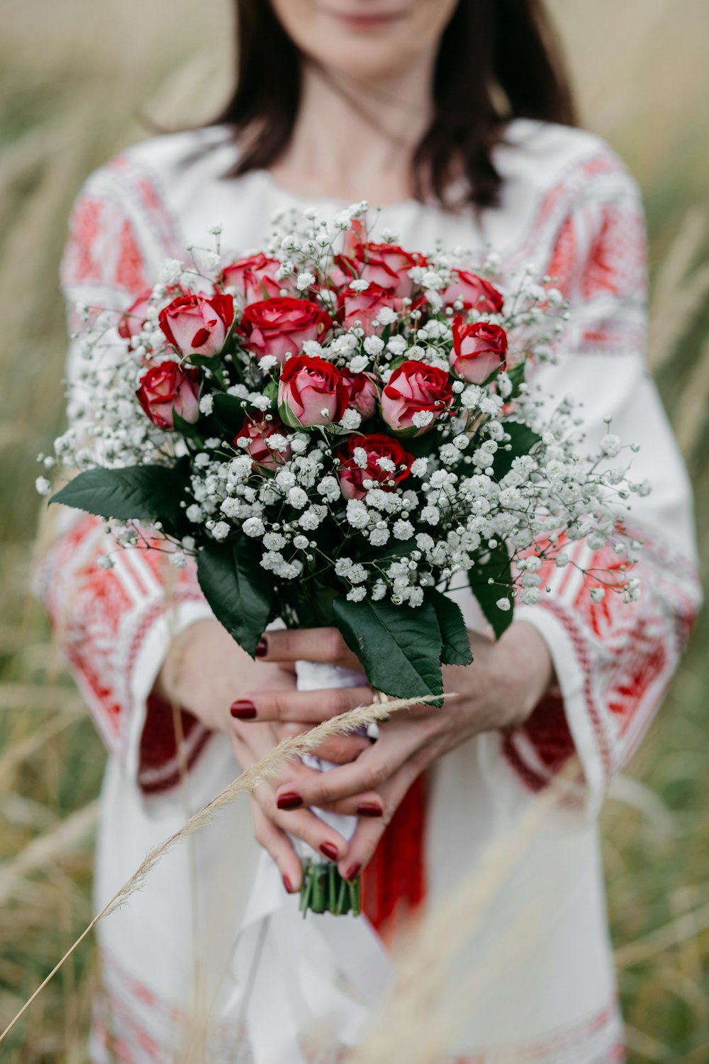 a woman holding a bouquet of red roses