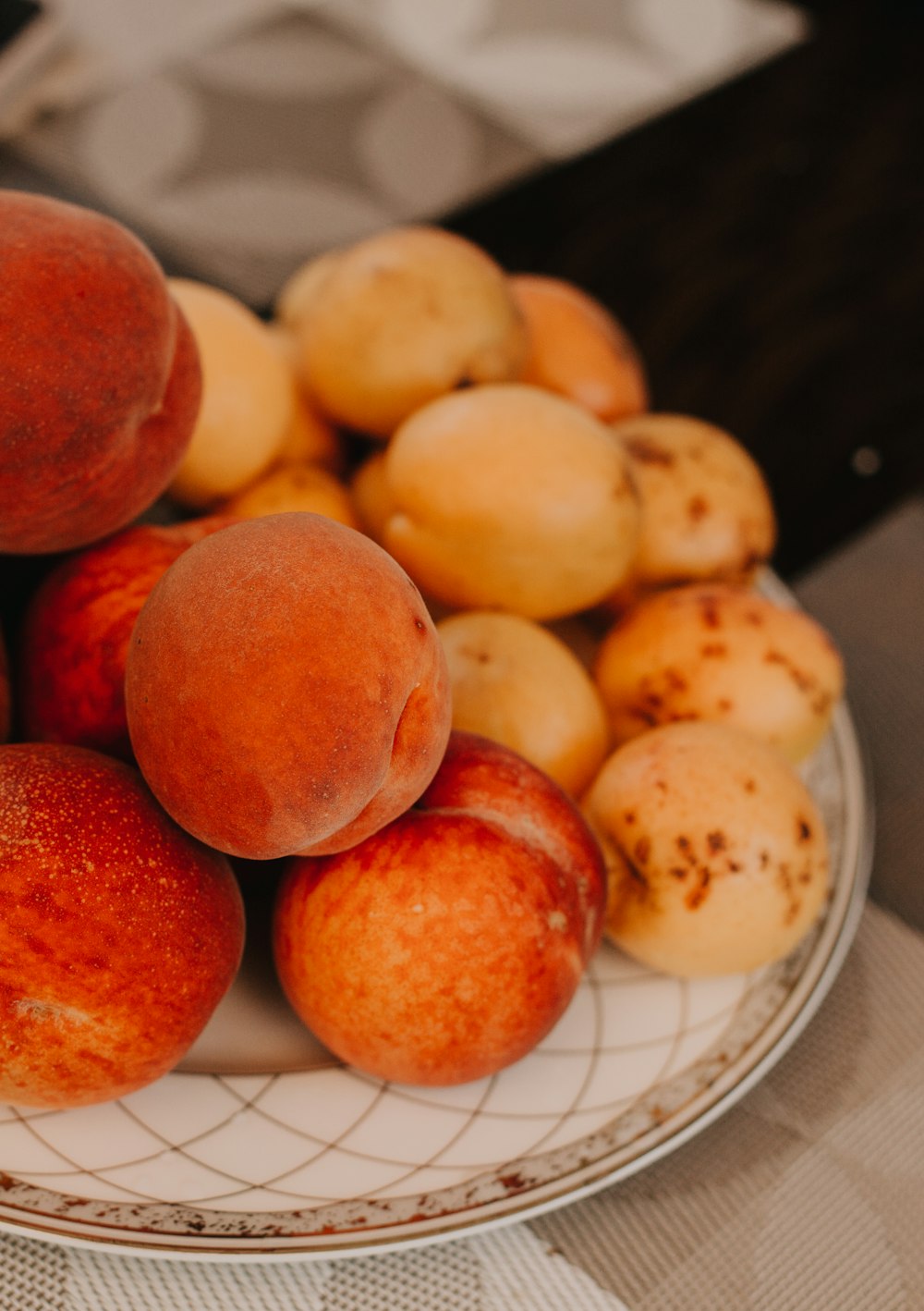 um prato branco coberto com muitos pêssegos maduros