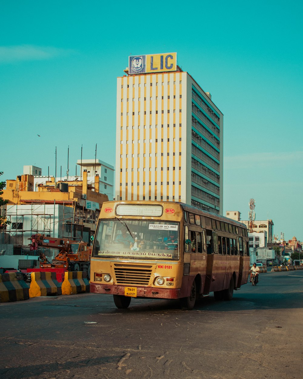 a bus driving down a street next to a tall building