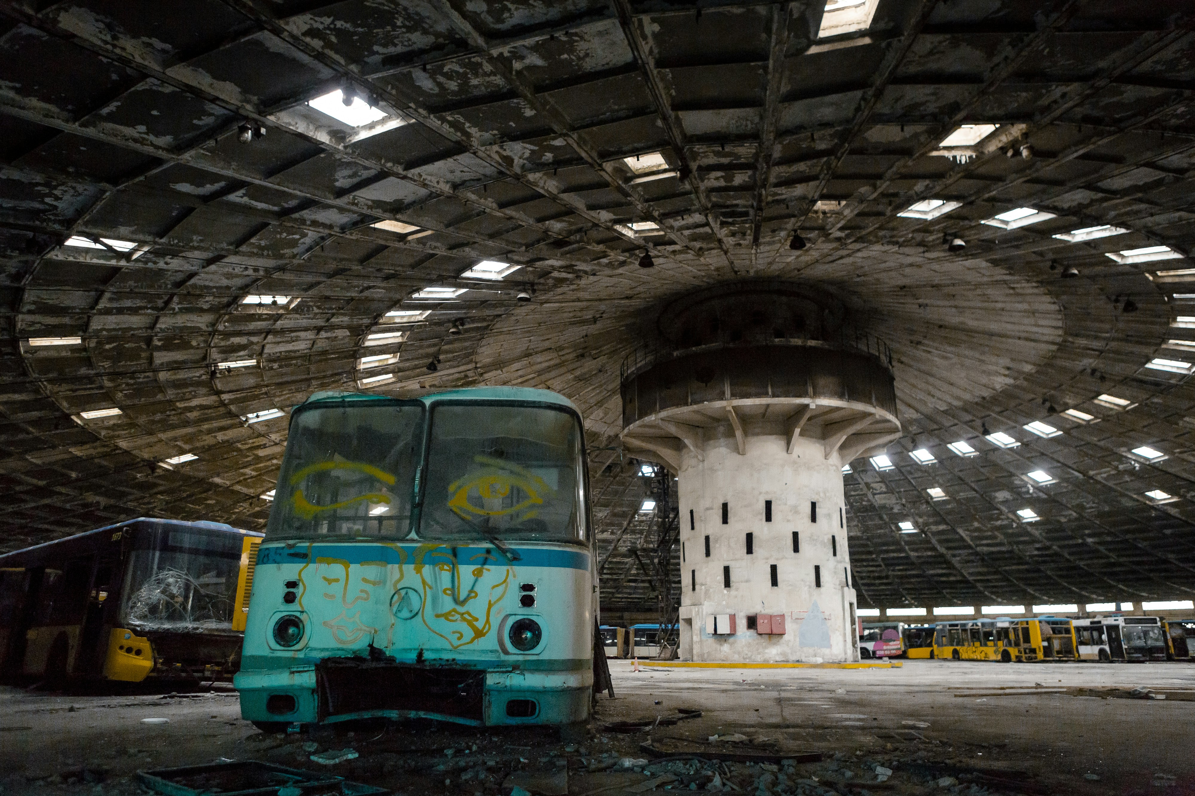 A blue and white bus parked inside of a building photo – Free Building ...