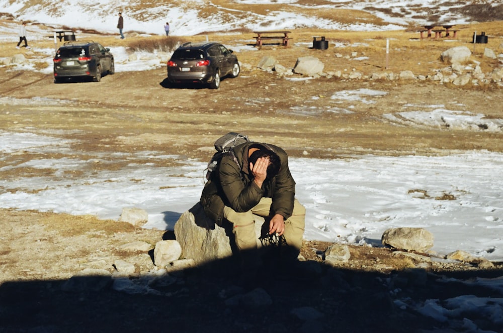 Un uomo seduto su una roccia che parla al cellulare