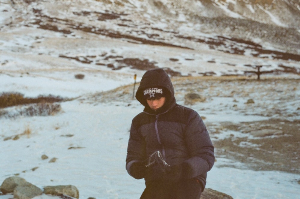 a person standing in the snow with a snowboard