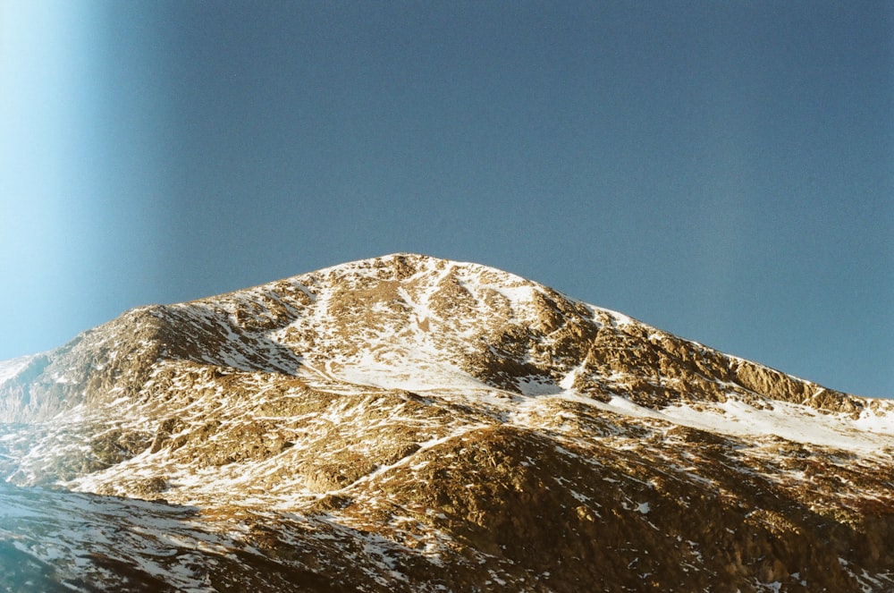 a snow covered mountain with a blue sky in the background