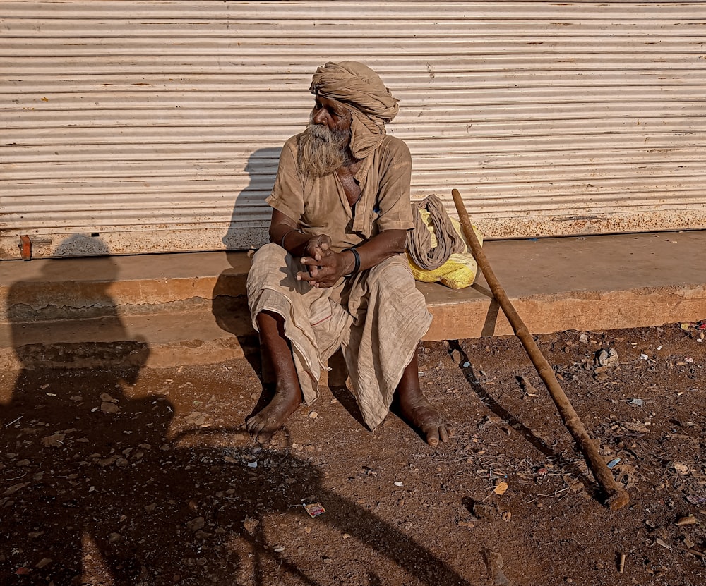 a man sitting on a bench next to a wall